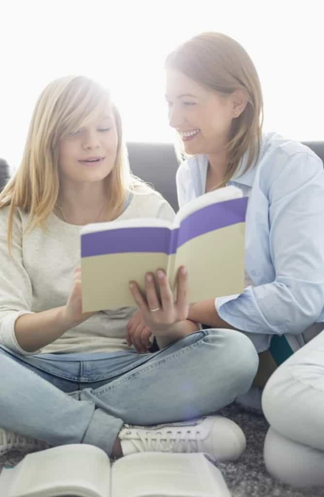 Mother and teen with blond hair smiling and reading together